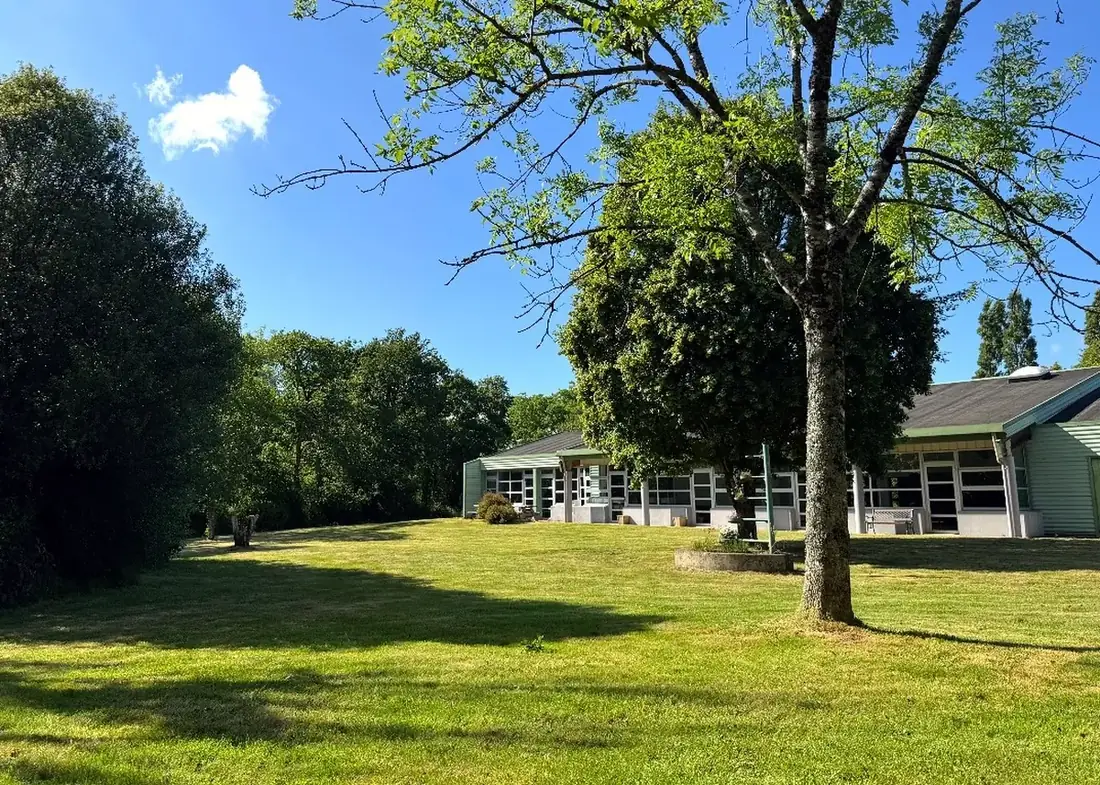 Le parc et la façade de la salle de réception de Tromelin à Mahalon, sous les arbres